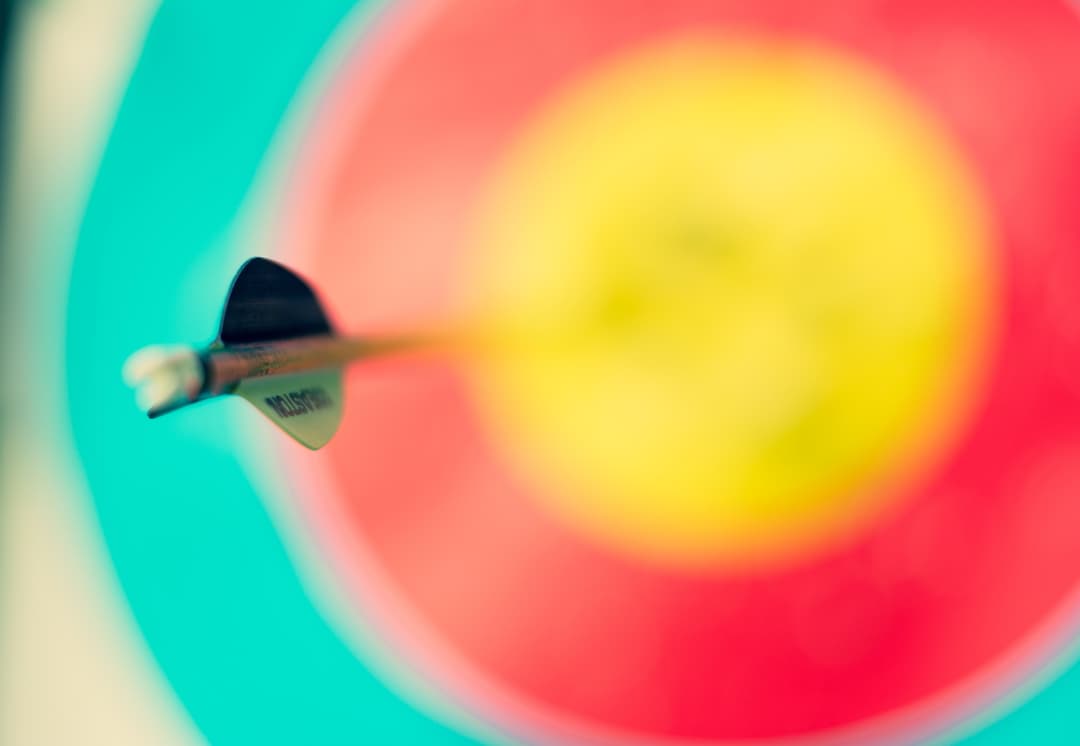 Flecha acerta o alvo desfocado nas cores branco, azul ciano, vermelho e amarelo